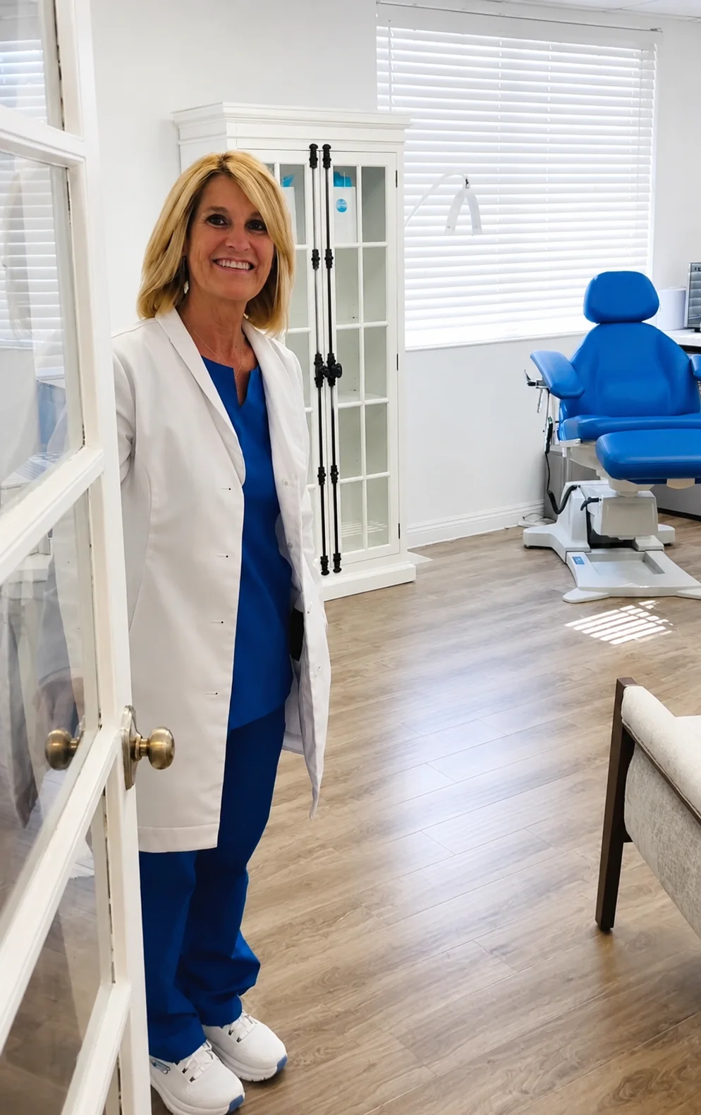 Warm welcome at Ascend Beauty & Wellness — bright treatment room with a smiling provider in a white coat
